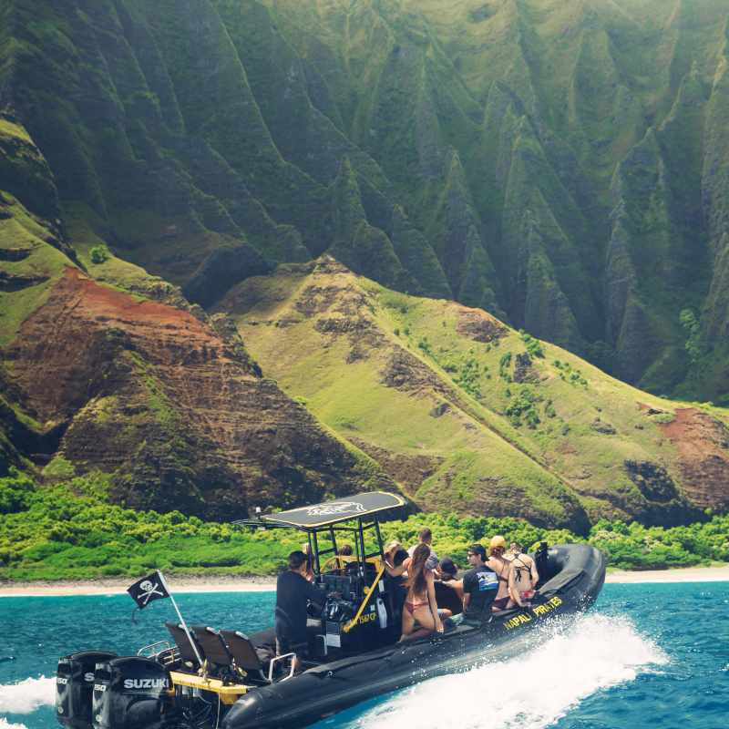 a group of people in a boat on the side of a mountain